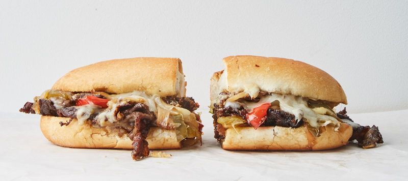 Individually wrapped cheesesteak sandwiches in a box