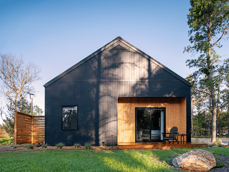 These 9 Woodsy Cabin Aesthetics From Michigan Retreats Will Inspire Your Exterior - Decor Hint Black-Framed Windows Creating Dramatic Forest Frames