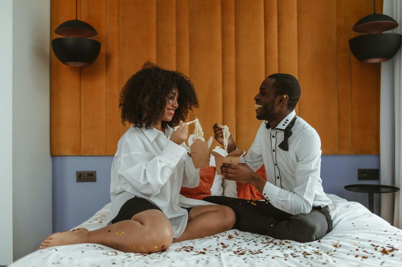 Binge-eating junk food together in bed